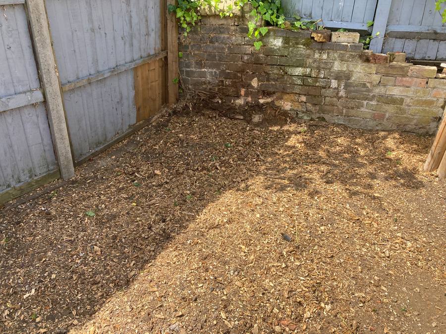 The same corner cleared, the stump gone and the ground covered in chippings